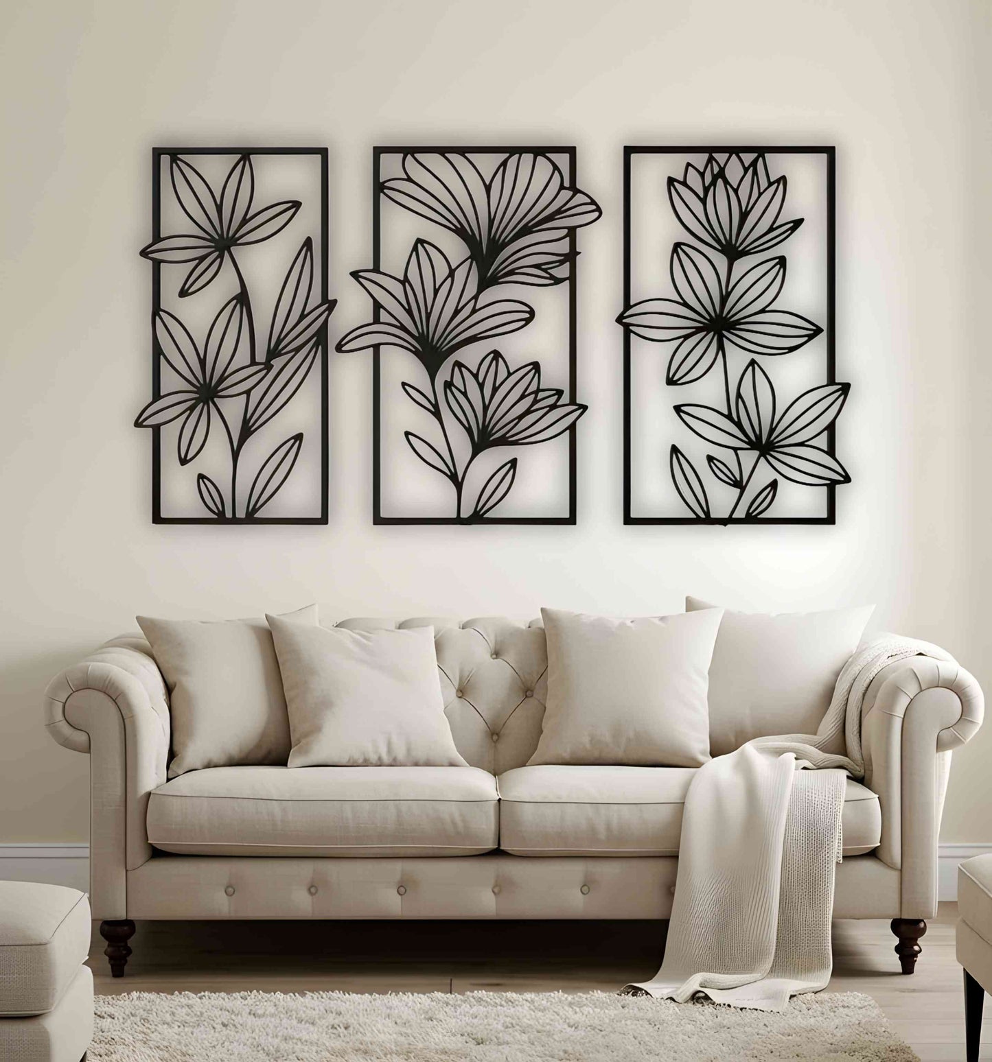 Three-piece floral wooden wall art set in matte black, mounted above a beige tufted sofa in a neutral-toned living room with cozy textures