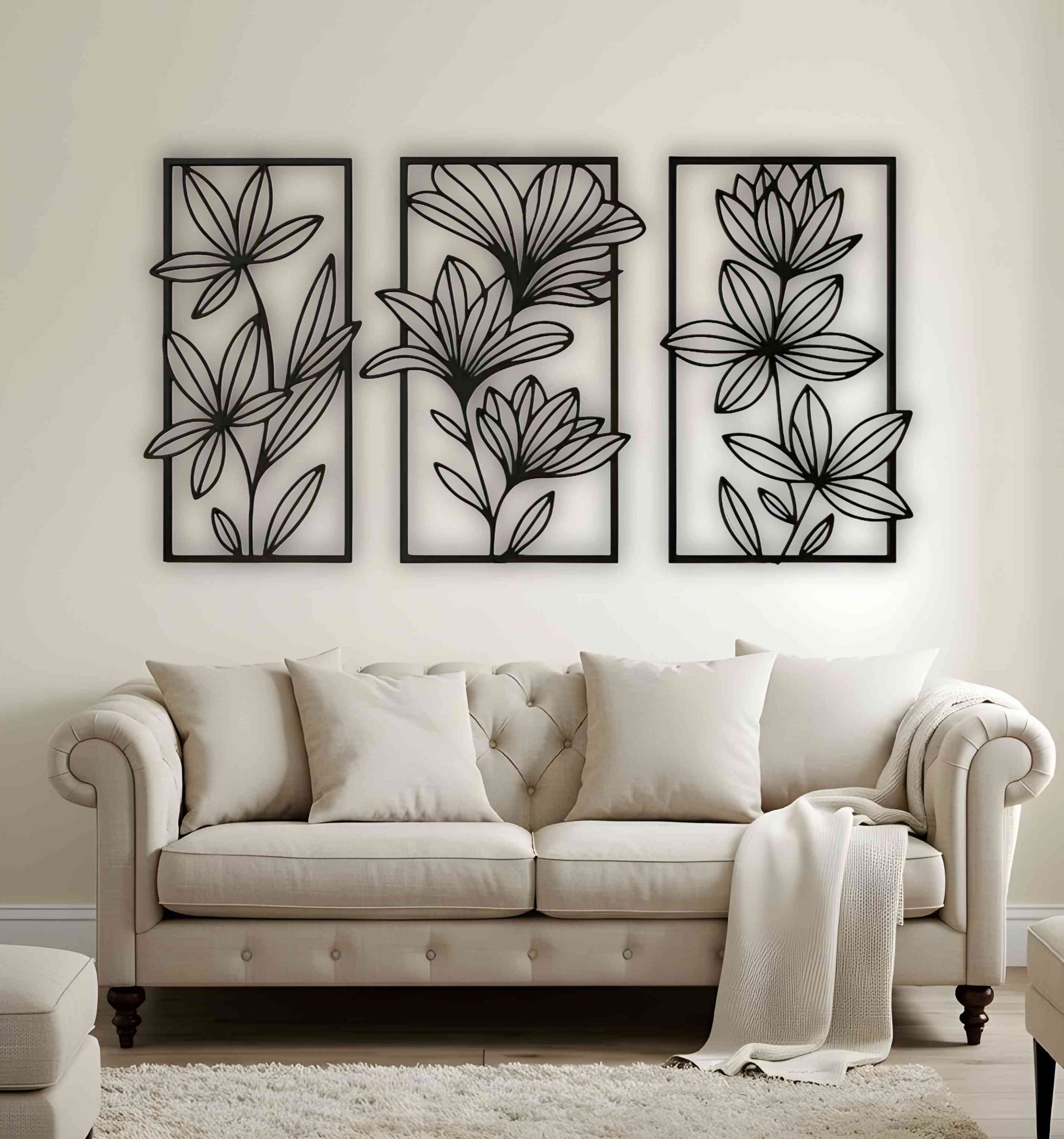 Three-piece floral wooden wall art set in matte black, mounted above a beige tufted sofa in a neutral-toned living room with cozy textures