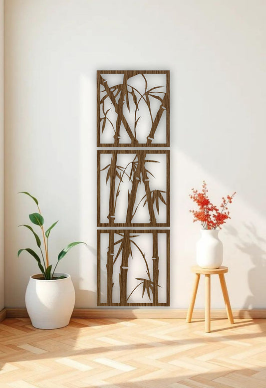 Vertical 3-piece wooden bamboo wall art panels in matte black, mounted on a white wall in a modern reading nook with beige armchair and green indoor plant.