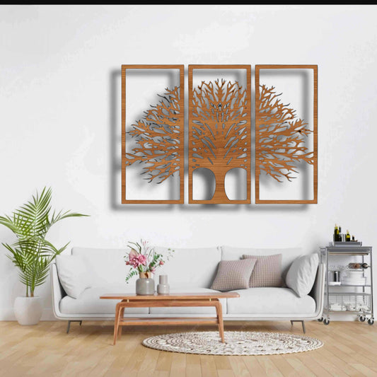 Three-piece black wooden Tree of Life wall art set mounted above a beige modern sofa, surrounded by indoor plants and minimalist decor.