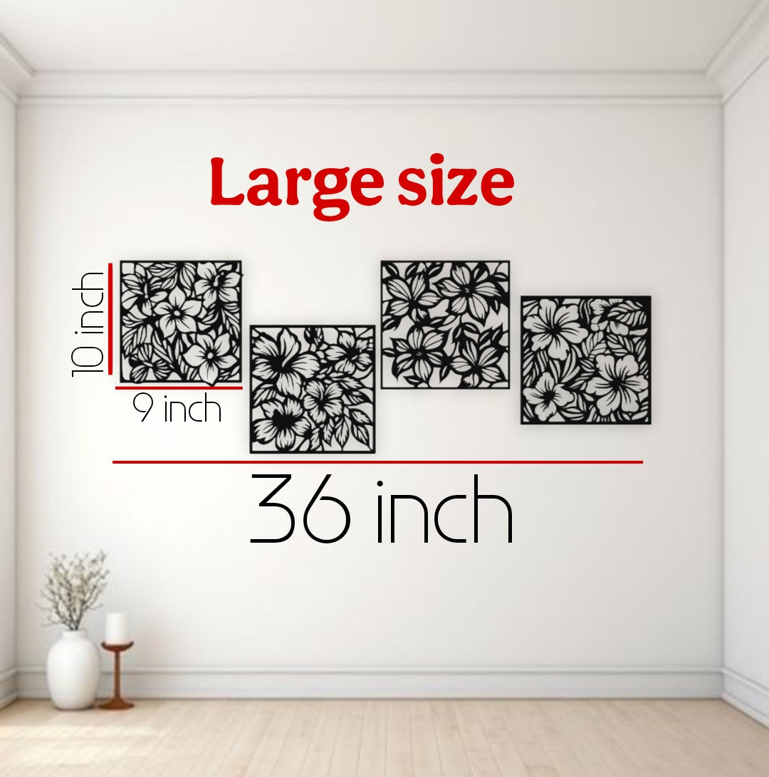 "Set of four black wooden laser cut floral wall art panels arranged above a white sectional sofa in a modern living room. Each panel features a detailed flower and leaf design, measuring 10x9 inches, with a total display width of 36 inches."