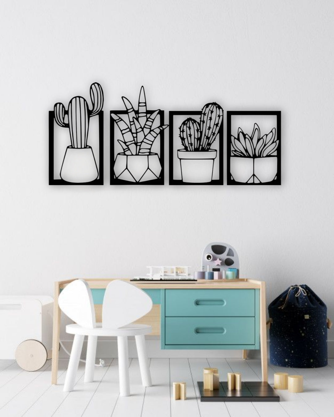 Set of four wooden cactus and succulent wall art panels in black, mounted above a turquoise and wood children’s study desk in a bright, modern kids’ room
