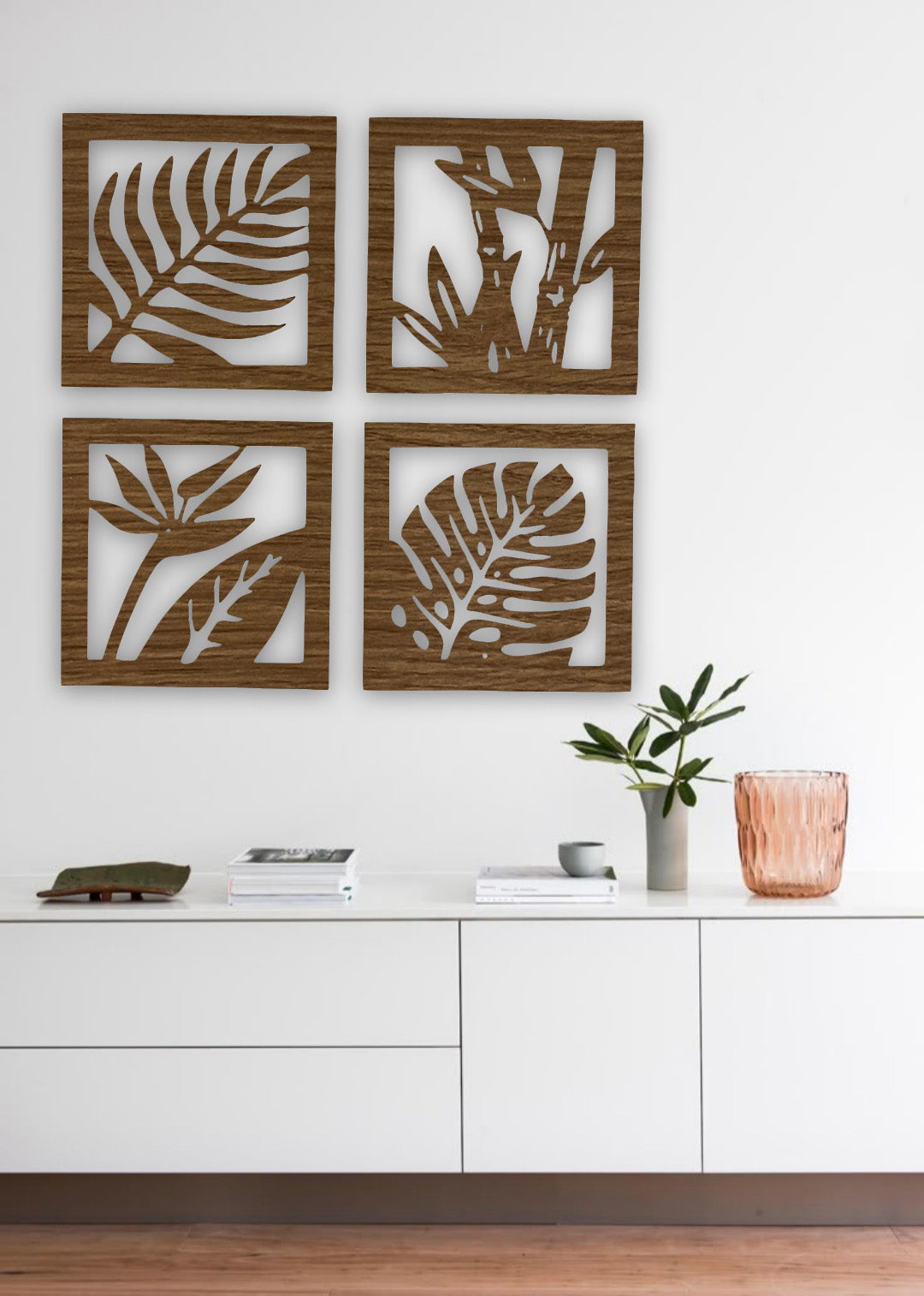 “Four-piece square wooden wall art set with tropical leaf and plant designs in black finish, mounted above a modern wooden sideboard.”