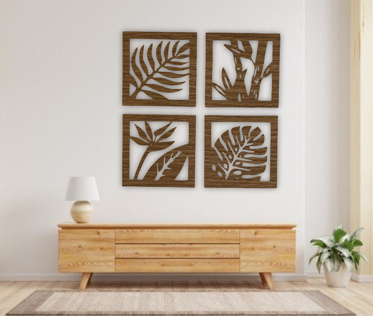 Four-piece square wooden wall art set with tropical leaf and plant designs in black finish, mounted above a modern wooden sideboard