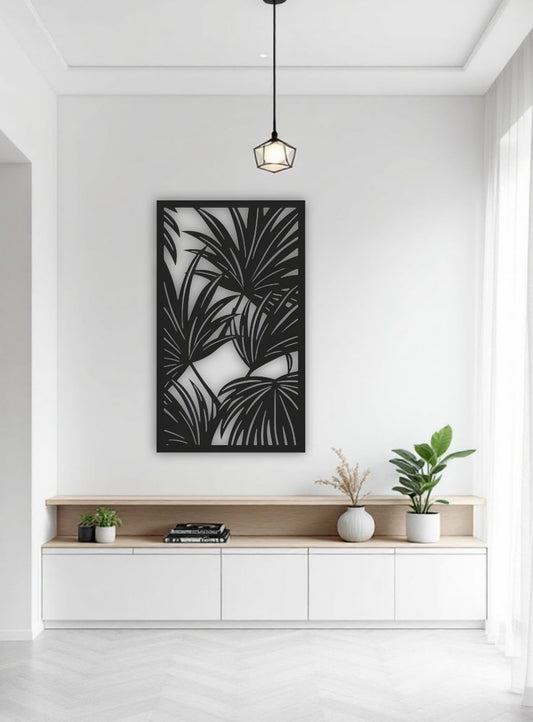 Black tropical leaf wooden wall art panel, 16x28 inches, displayed above a modern cabinet in a minimalist white room with indoor plants and soft lighting