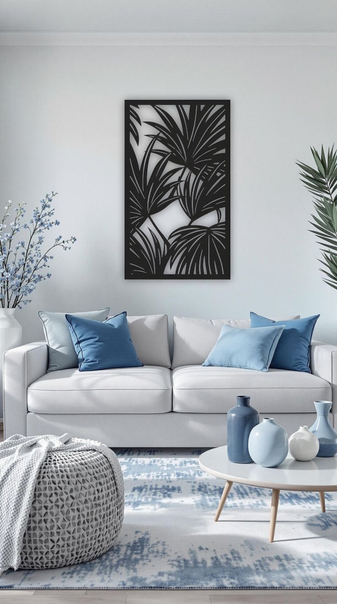 Black tropical leaf wooden wall art panel, 16x28 inches, displayed above a modern cabinet in a minimalist white room with indoor plants and soft lighting