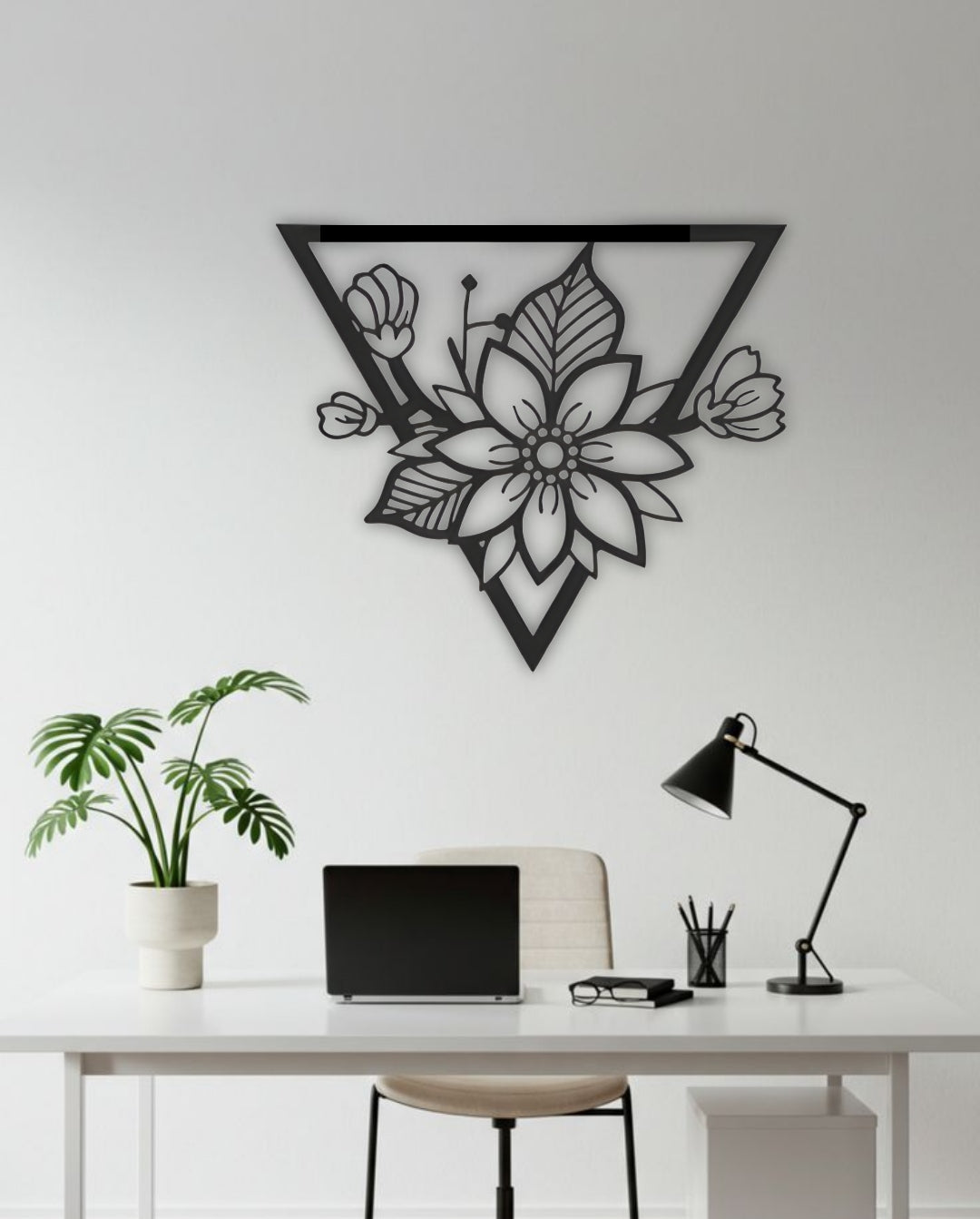 Triangle-shaped floral wooden wall art in black, displayed above a modern white office desk setup