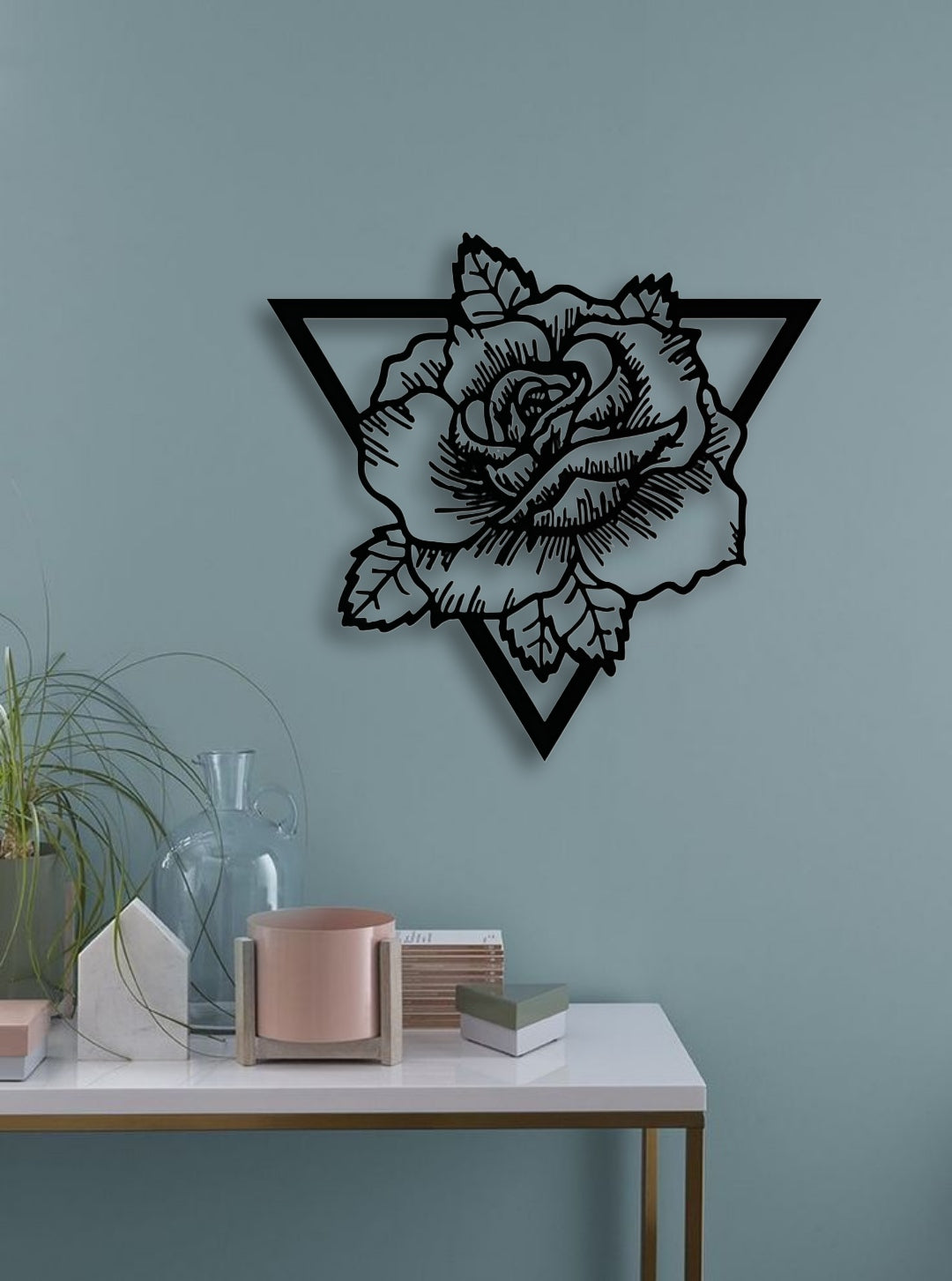 Geometric rose wall art in black wood finish, styled on a teal wall above a modern console table with minimalist décor elements.