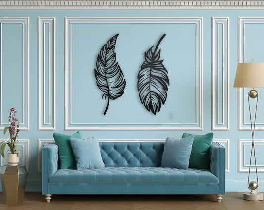 Stylish dual-feather wall art in matte black finish mounted on a blue paneled wall above a tufted sofa.