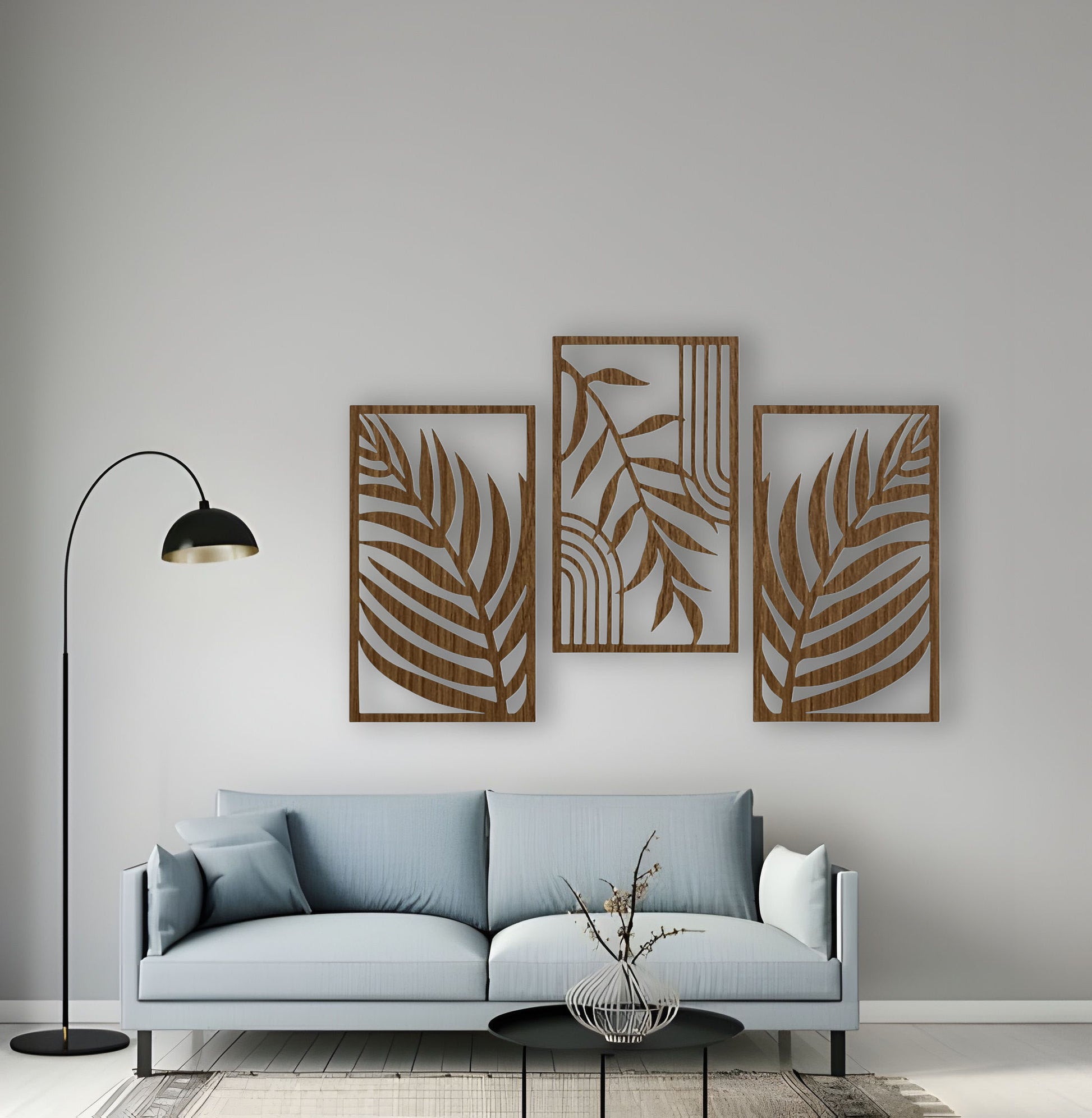 Set of three wood brown wall panels with abstract tropical leaves, mounted in a cozy, modern living room with warm neutral tones