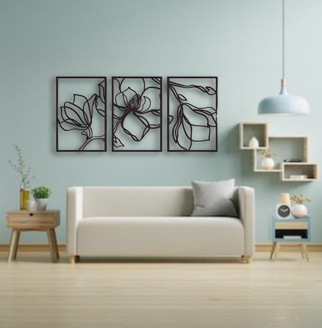 Three-piece floral wooden wall art in matte black finish mounted above a wooden slatted console table in a modern interior setting