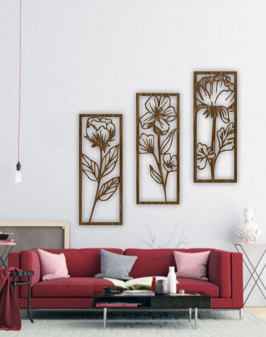 Three-piece floral wall art panels in natural wood brown finish, mounted on a white wall in a minimalist room with indoor plants.