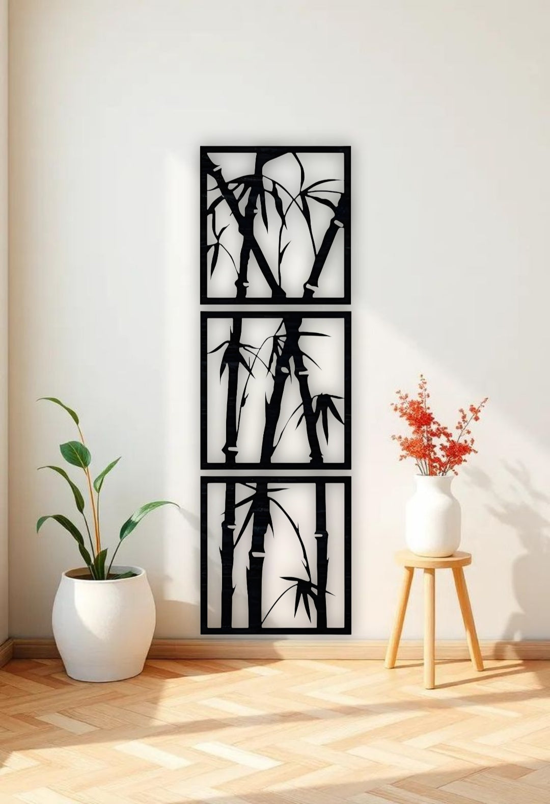 Vertical 3-piece wooden bamboo wall art panels in matte black, mounted on a white wall in a modern reading nook with beige armchair and green indoor plant.