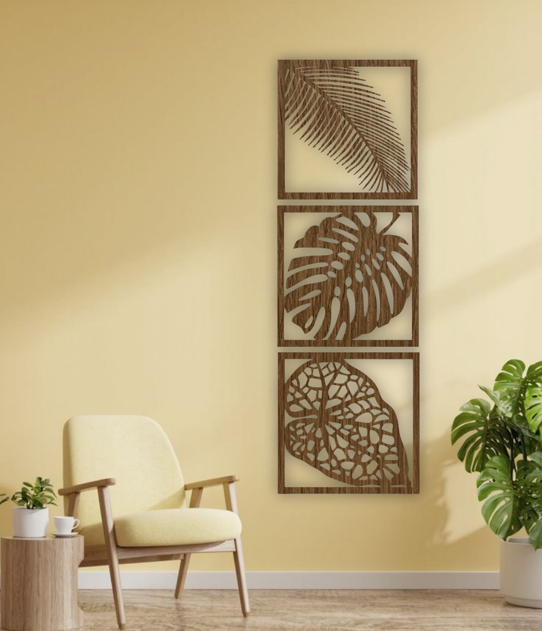 Three-piece vertical black wooden wall art set with palm, monstera, and vine leaf designs, mounted beside a cream sofa on a white wall.