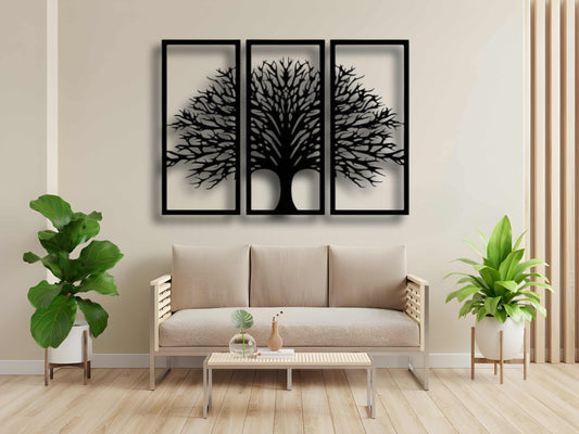 Three-piece black wooden Tree of Life wall art set mounted above a beige modern sofa, surrounded by indoor plants and minimalist decor.