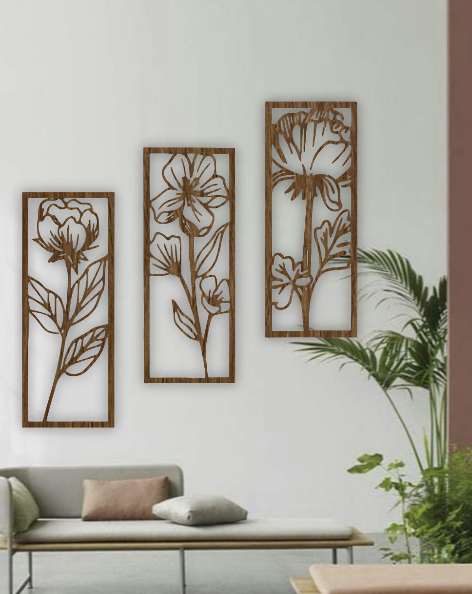Three-piece floral wall art panels in natural wood brown finish, mounted on a white wall in a minimalist room with indoor plants.