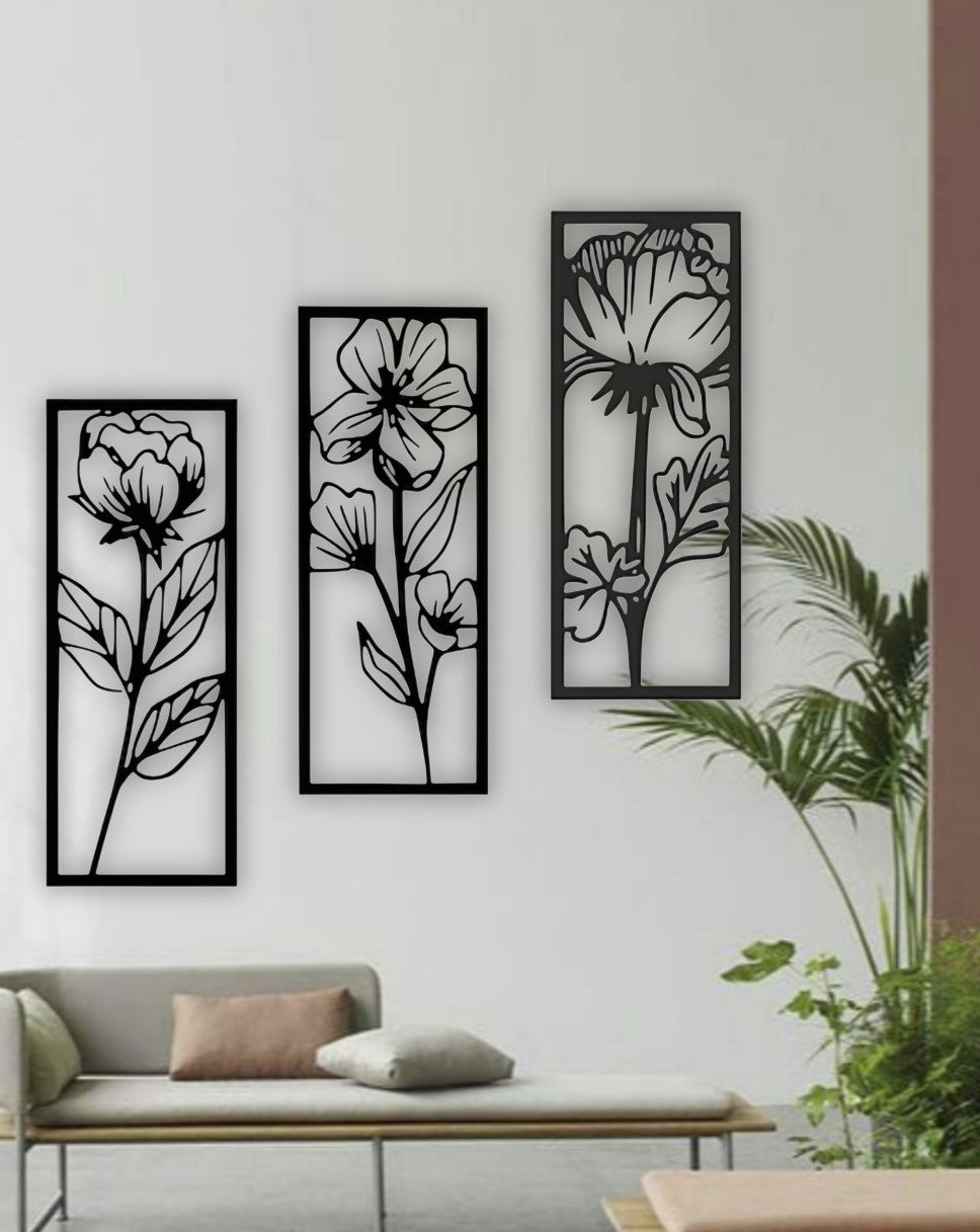 Set of three vertical floral wall art panels in black wooden finish, displayed above a red modern sofa in a stylish living room setting.