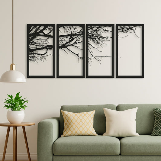 Four framed black and white tree artworks above a green sofa with decorative pillows.