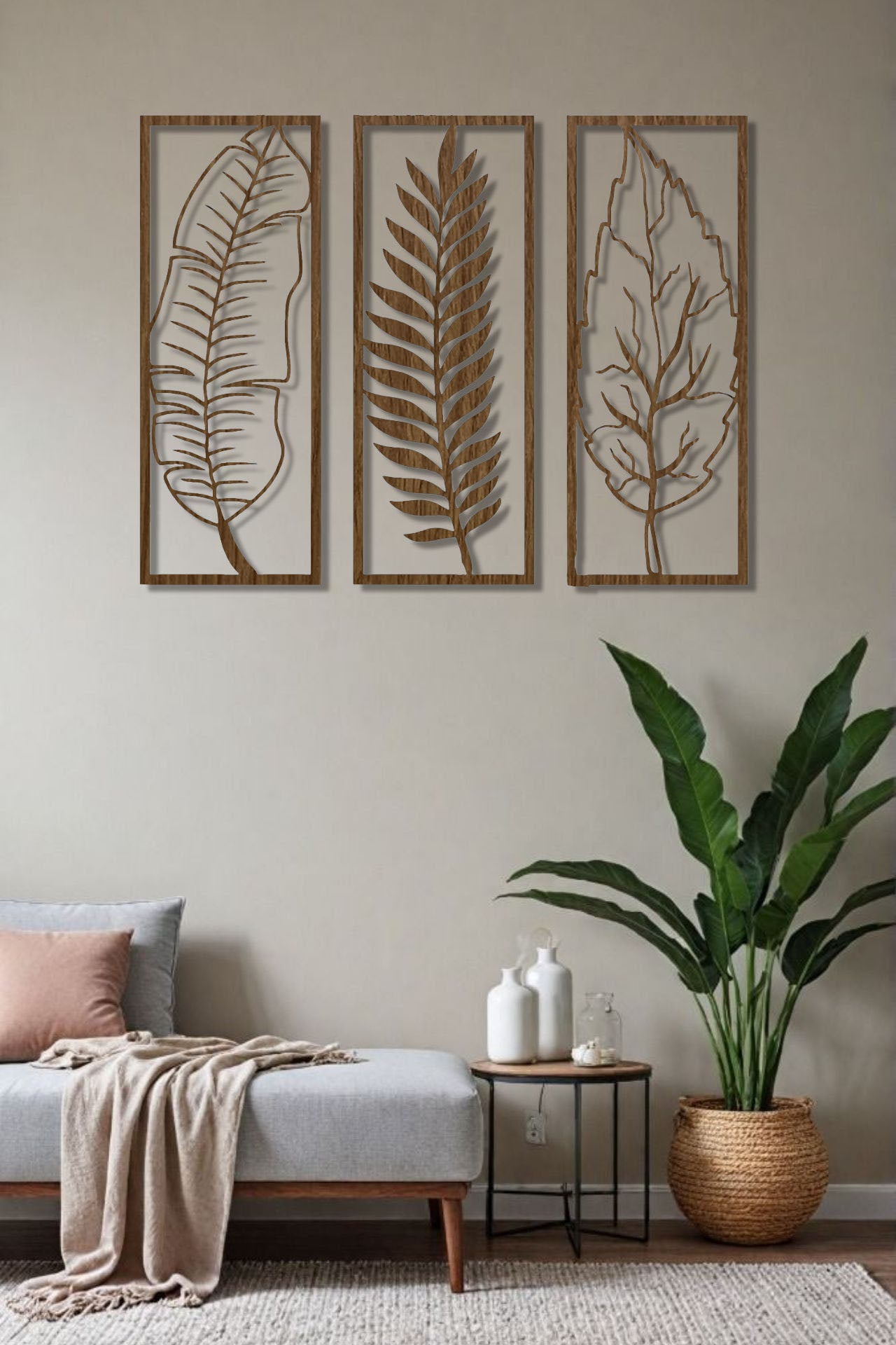 Natural wood brown 3-piece vertical leaf wall art set with botanical designs, displayed in a neutral-toned room beside indoor plants.