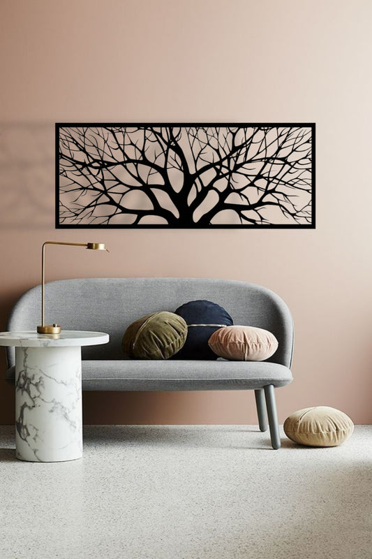 Modern living room with a gray sofa, decorative pillows, a marble side table, and a wall art piece of black tree branches.