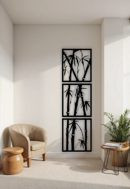 Vertical 3-piece wooden bamboo wall art panels in matte black, mounted on a white wall in a modern reading nook with beige armchair and green indoor plant.