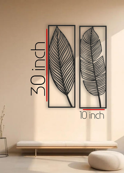 tall black woodeTwo n wall art panels with leaf designs, each 30 x 10 inches, mounted vertically above a sage green sectional in a modern living room