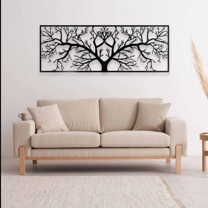 Beige sofa in a living room with a black and white tree wall art above it.