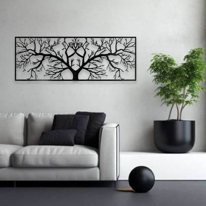 Modern living room with a black tree branch wall art, gray sofa, and potted plant.