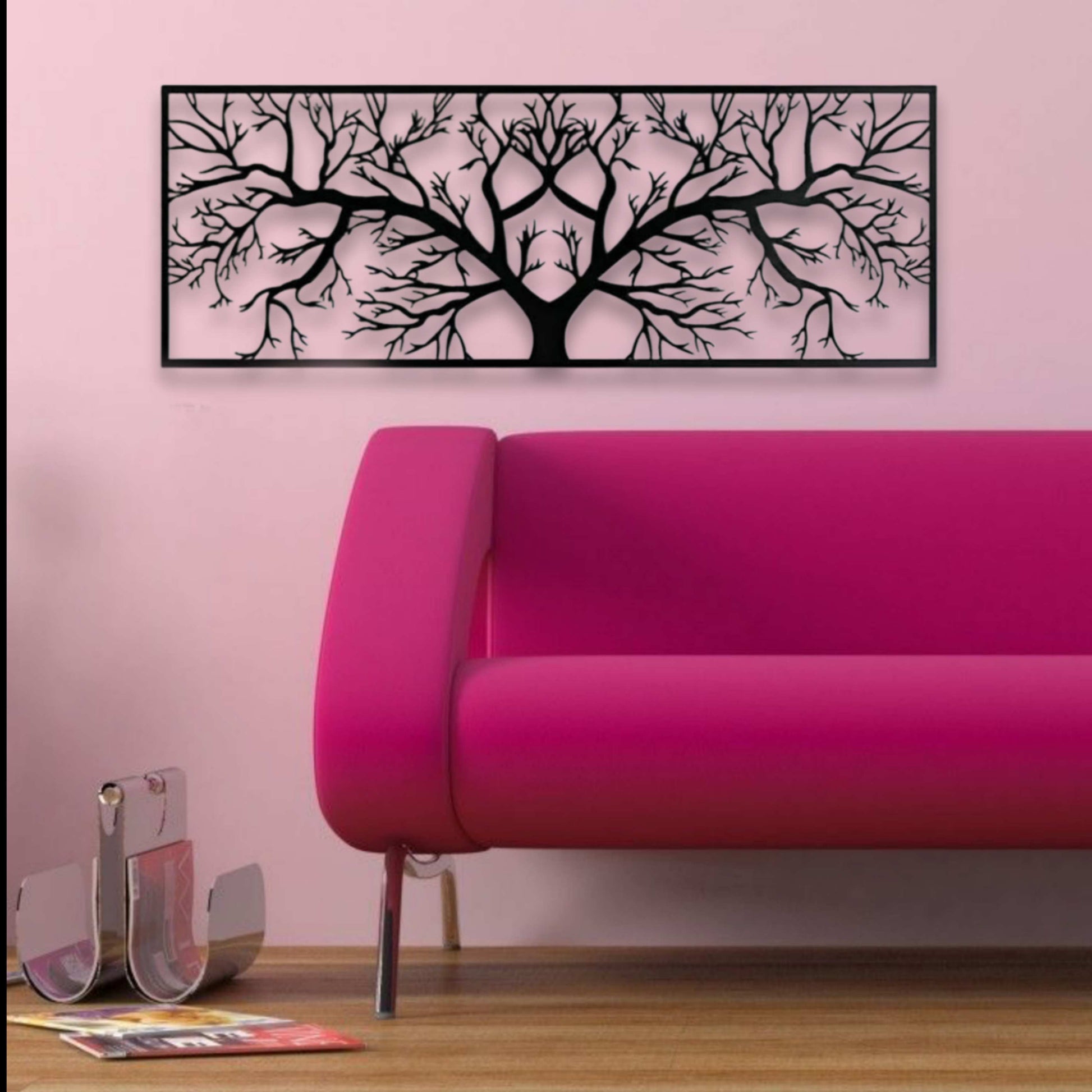 Pink sofa in a room with a decorative wall art piece on a pink wall.